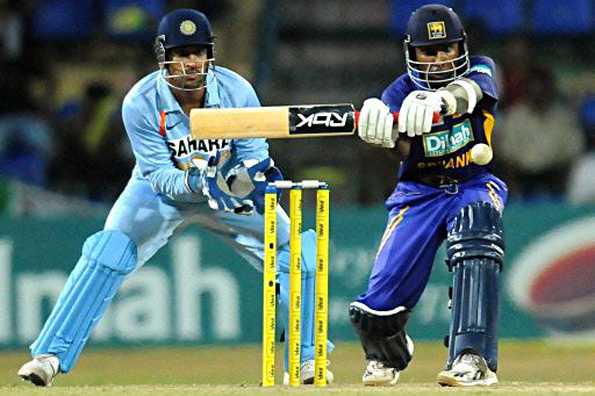 Sri Lanka cricket captain Mahela Jayawardene (R) is watched by Indian wicketkeeper captain Mahendra Singh Dhoni (L) as he plays a shot during the third One Day International (ODI) match between Sri Lanka and India at The R. Peremadasa Stadium in Colombo. India won by 33 runs.